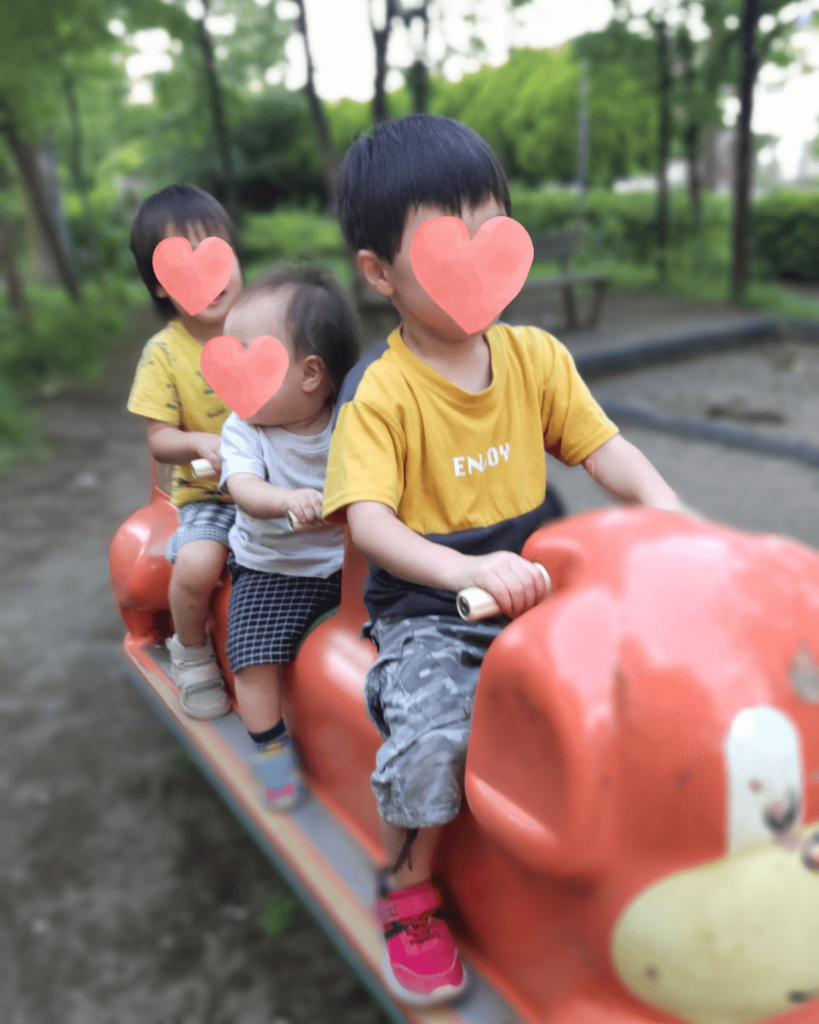 3人の子どもが遊具で遊んでいる
