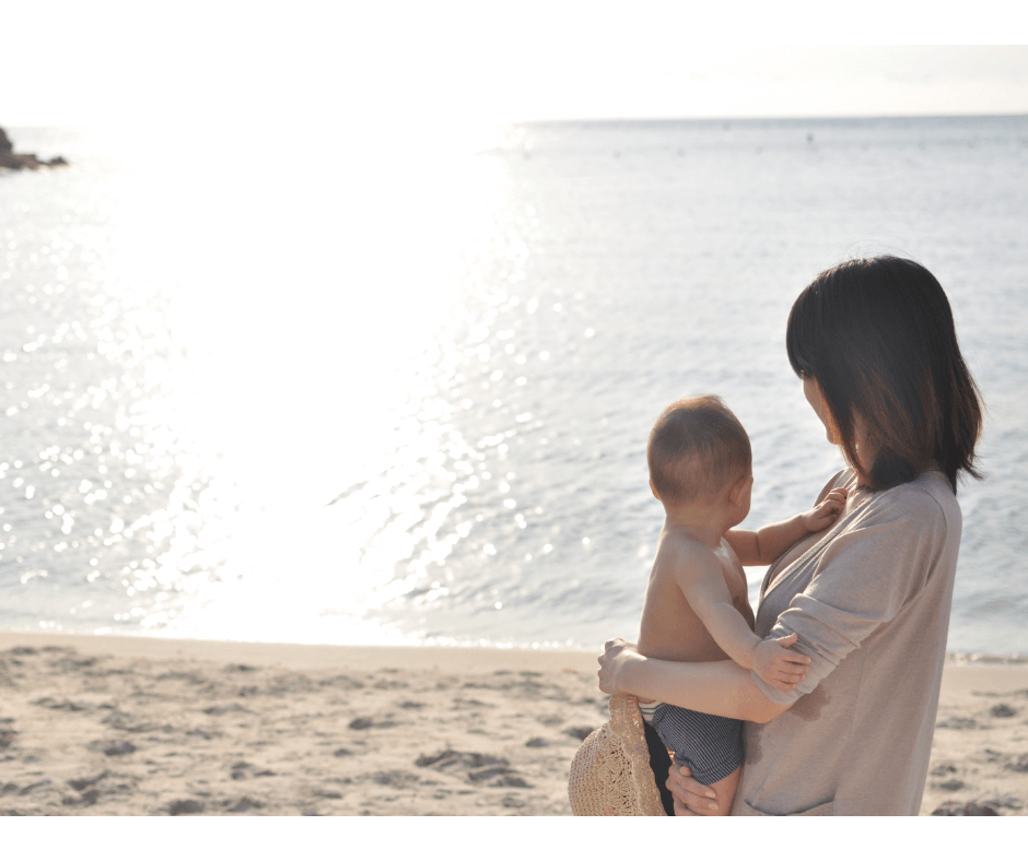 海を見つめてリラックスするママと赤ちゃん