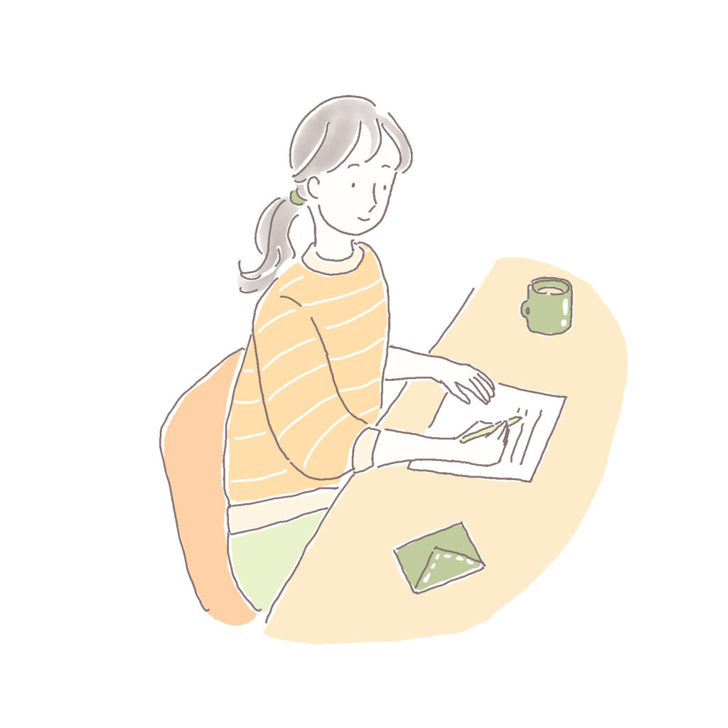 机に向かって手紙を書く女性