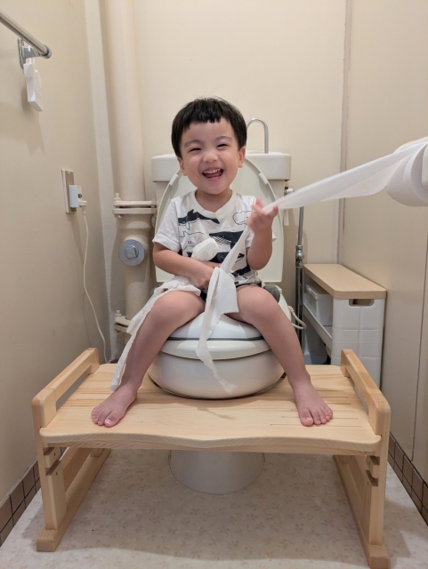 笑顔でトイレに座る男の子